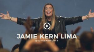 Jamie Kern Lima with arms outstretched, addressing a crowd. @JamieKernLima